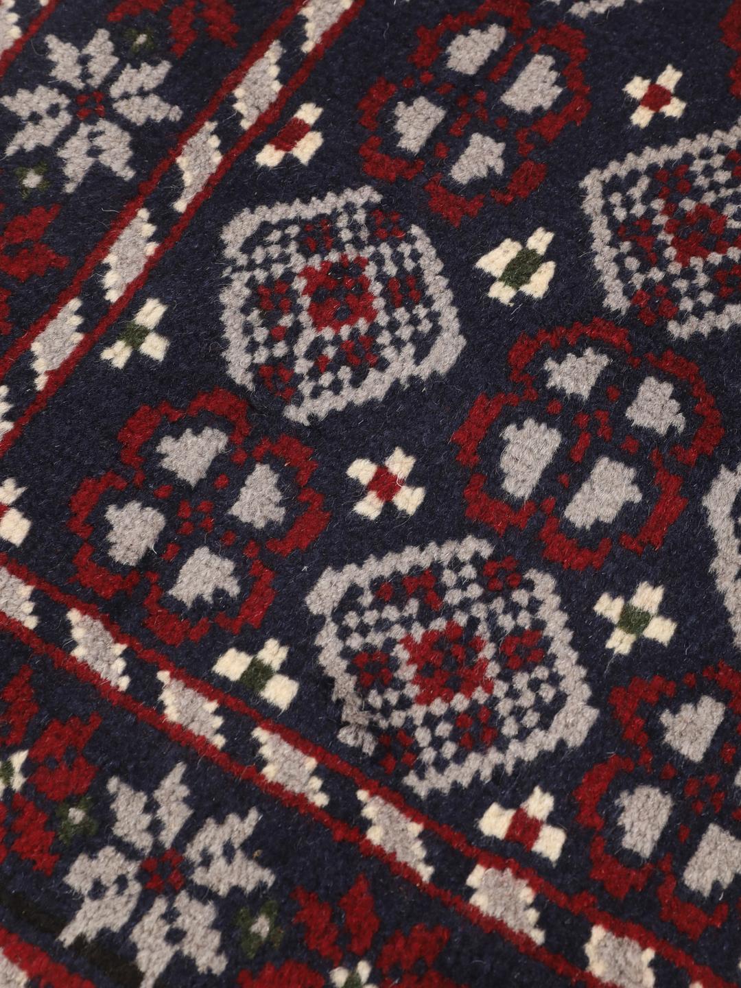 Handmade Baluch rug from the Middle East in dark-blue and dark-red tones.