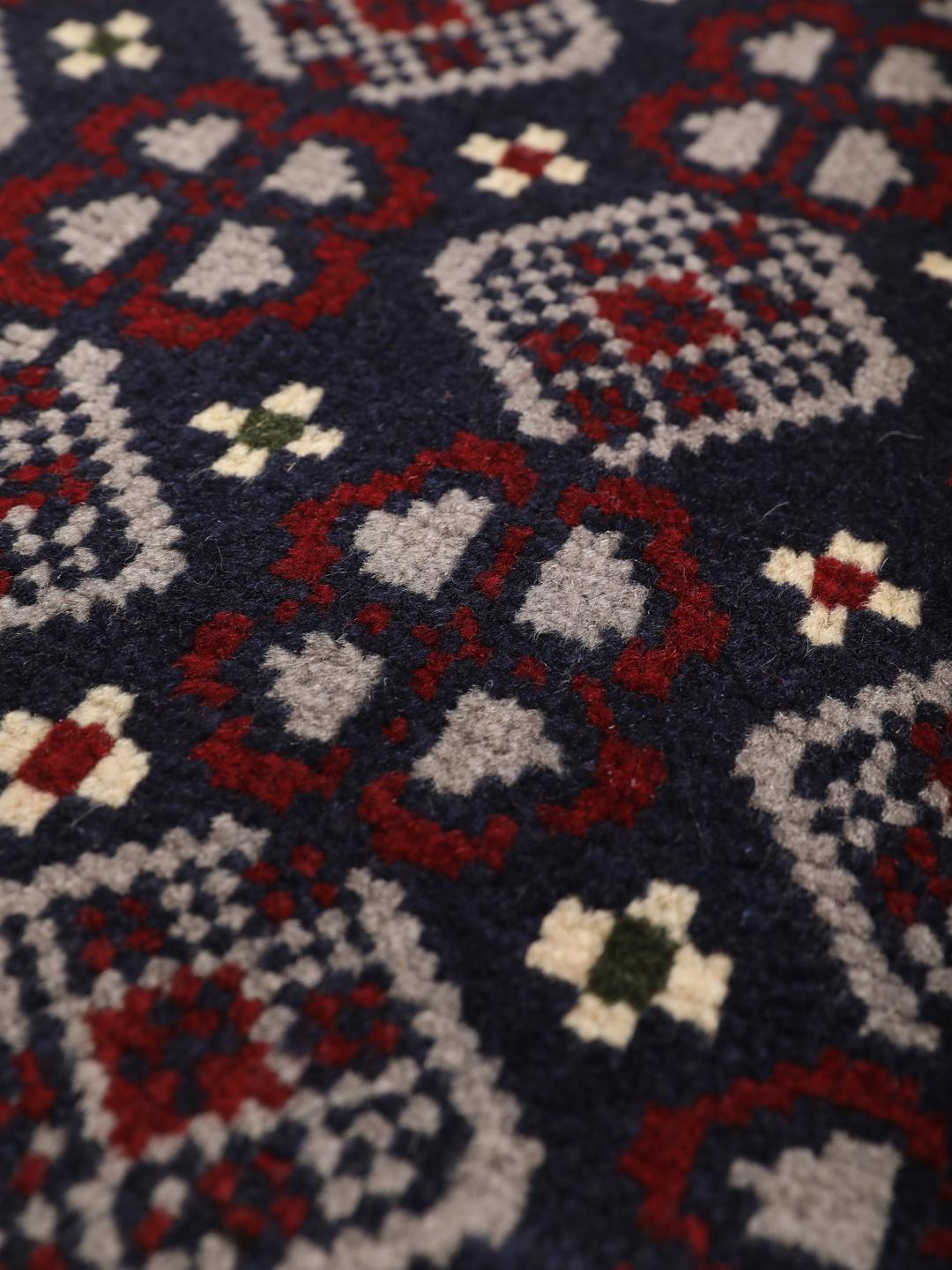 Handmade Baluch rug from the Middle East in dark-blue and dark-red tones.