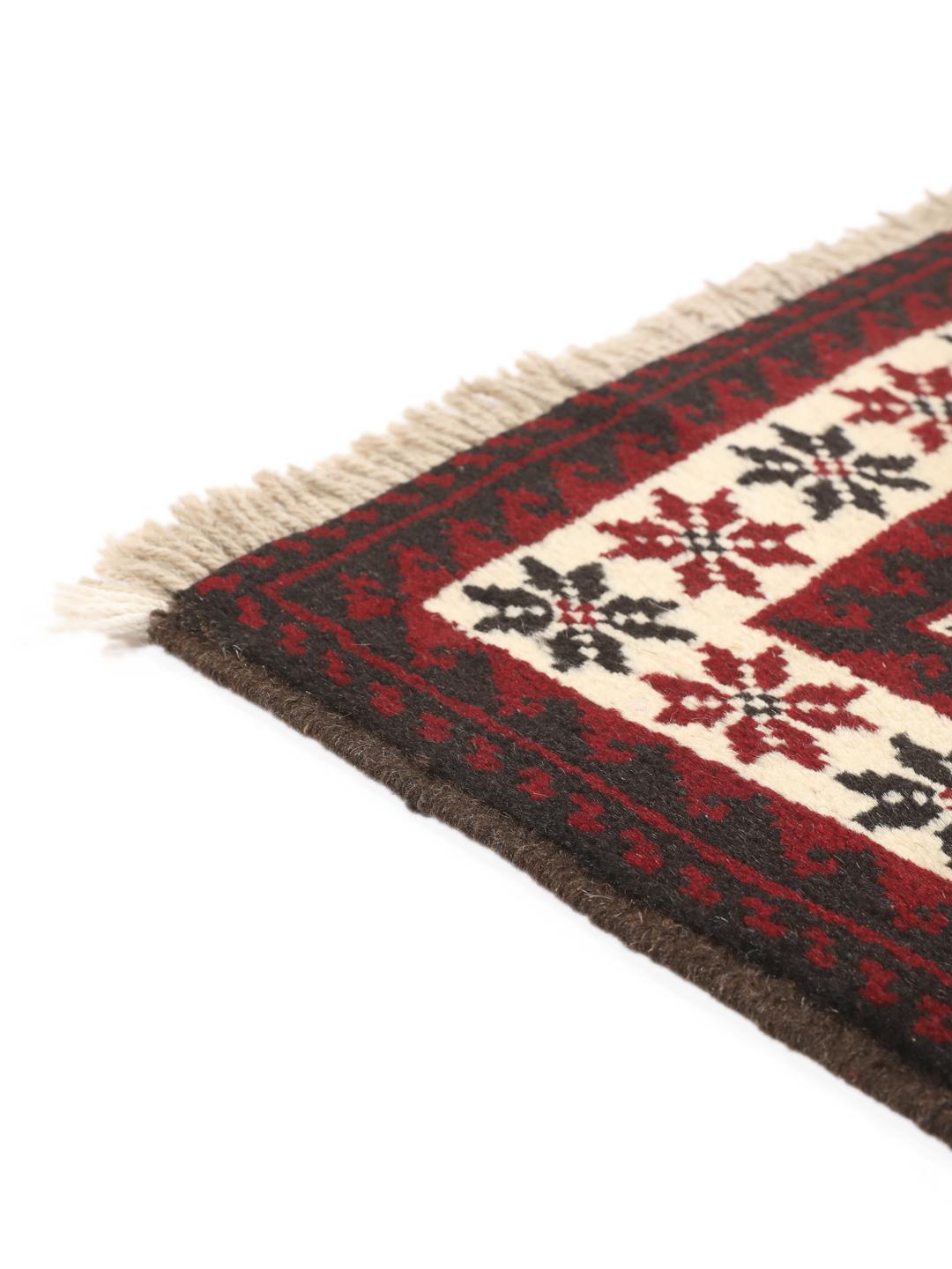 A hand-knotted Baluch rug from the Middle East featuring a red and beige geometric pattern.