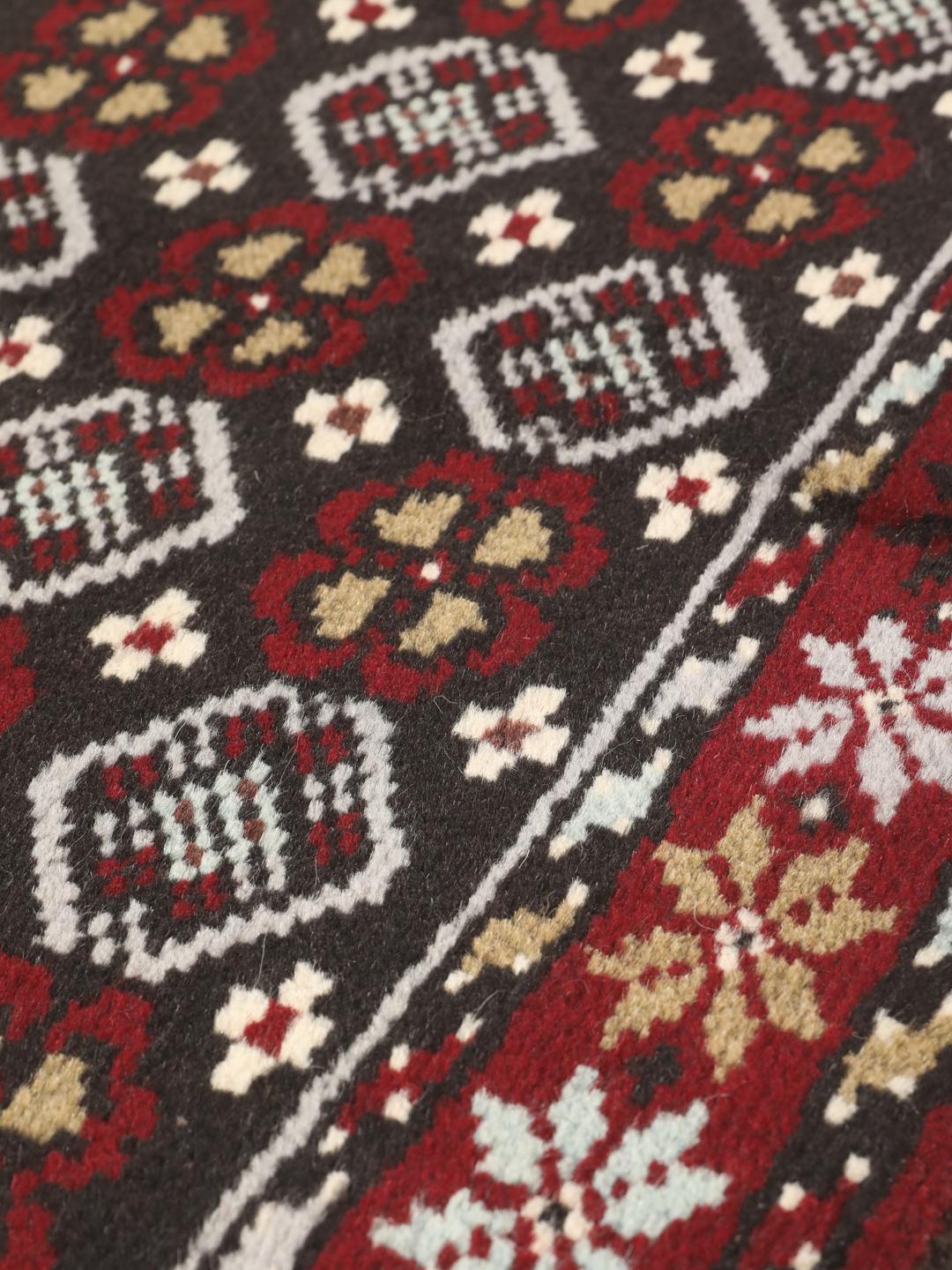 Hand-knotted Baluch rug in dark-red and black with traditional tribal geometric patterns