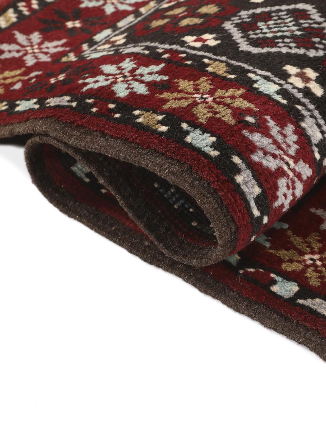 Hand-knotted Baluch rug in dark-red and black with traditional tribal geometric patterns