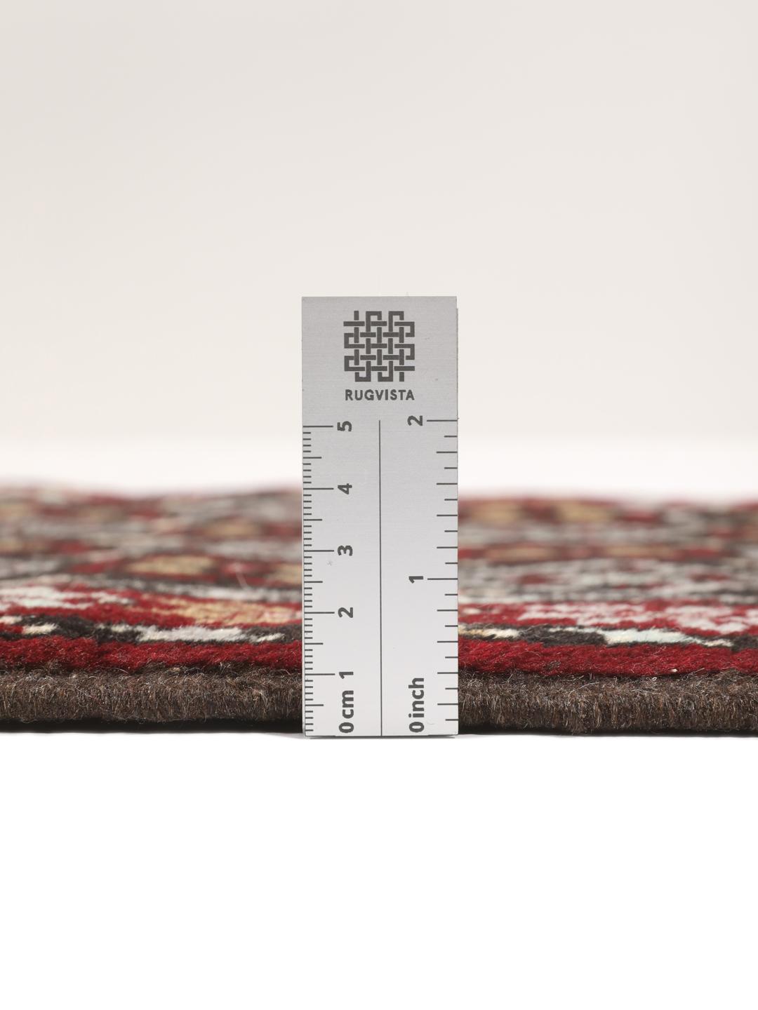 Hand-knotted Baluch rug in dark-red and black with traditional tribal geometric patterns