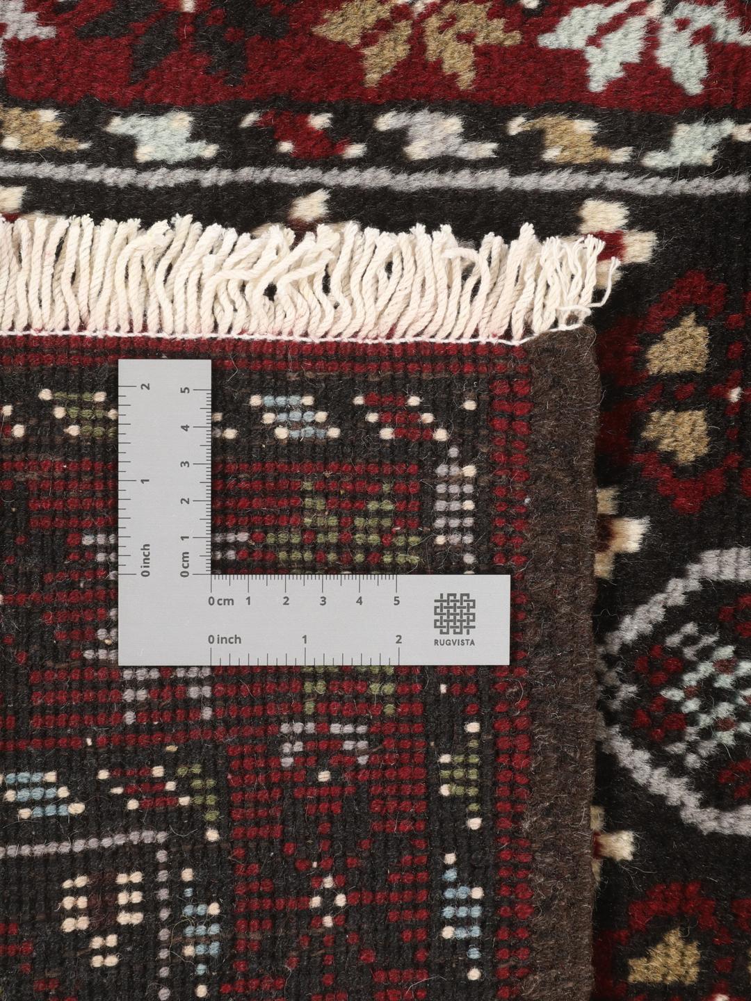 Hand-knotted Baluch rug in dark-red and black with traditional tribal geometric patterns