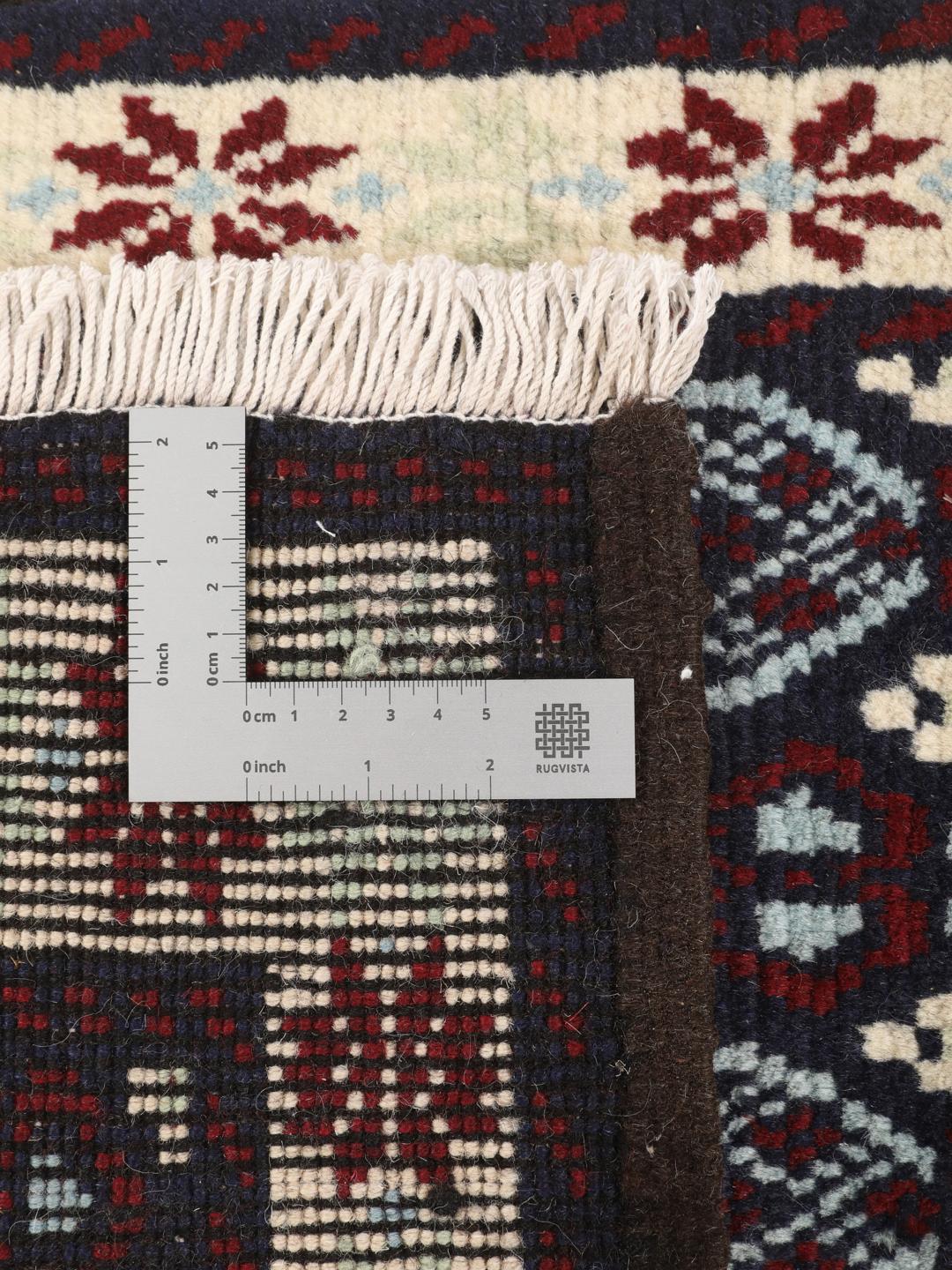 Håndknyttet tæppe fra Mellemøsten i mørkeblå og røde nuancer.