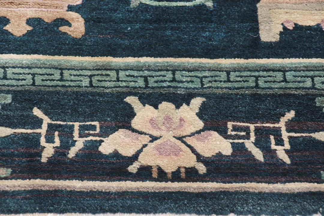 Antique Chinese hand-knotted rug in deep blue and black with floral motifs