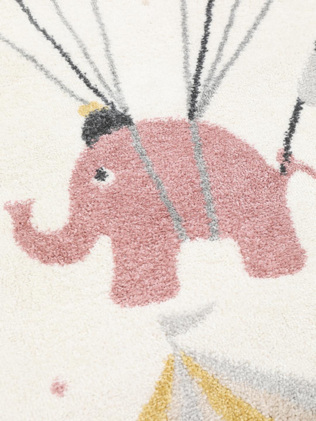 Et legende tæppe med cirkustema, der viser en lyserød elefant og en abe på en råhvid baggrund