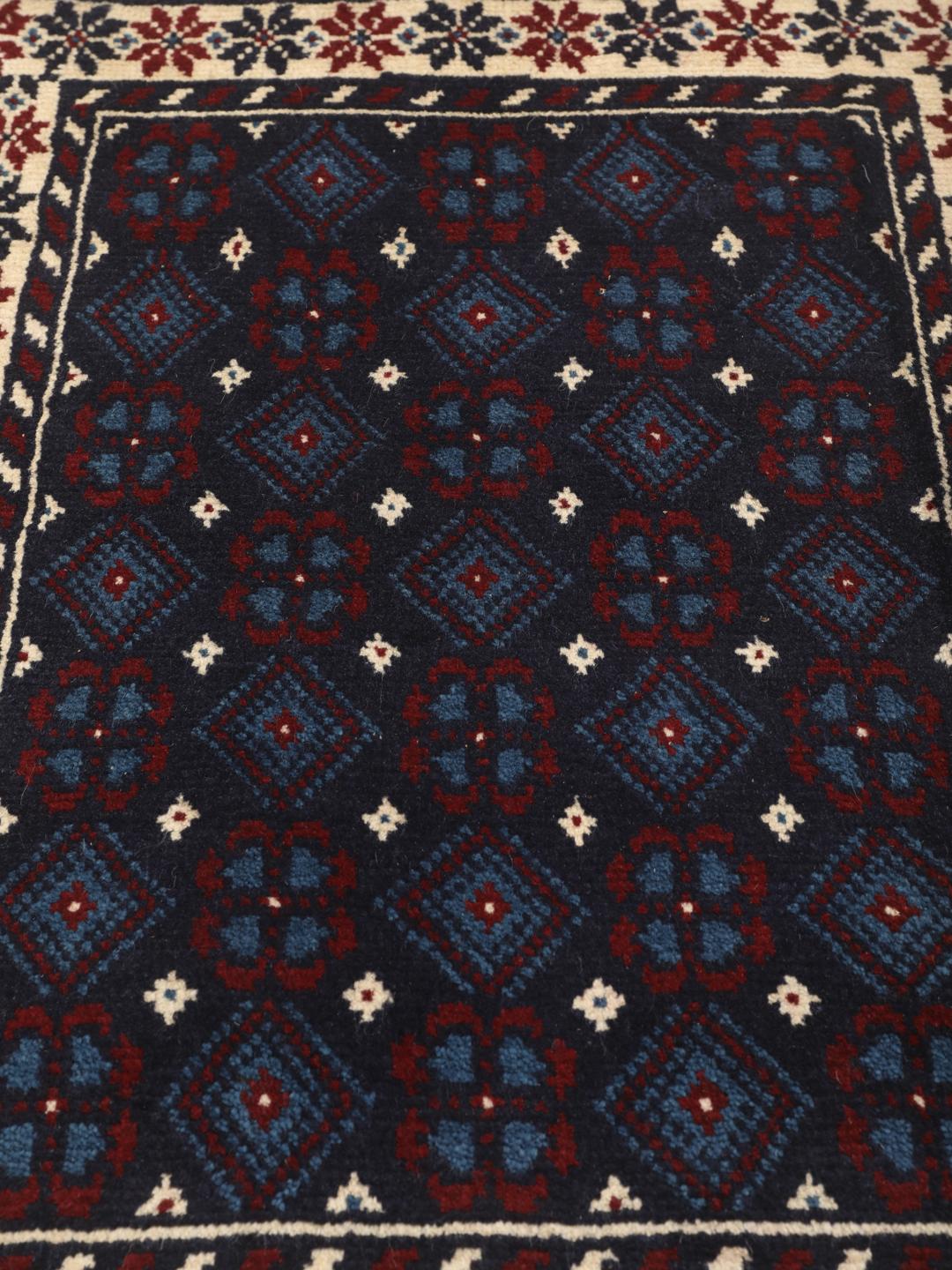 Handgeknoopt Beluch-tapijt uit het Midden-Oosten in blauwe, rode en beige tinten.
