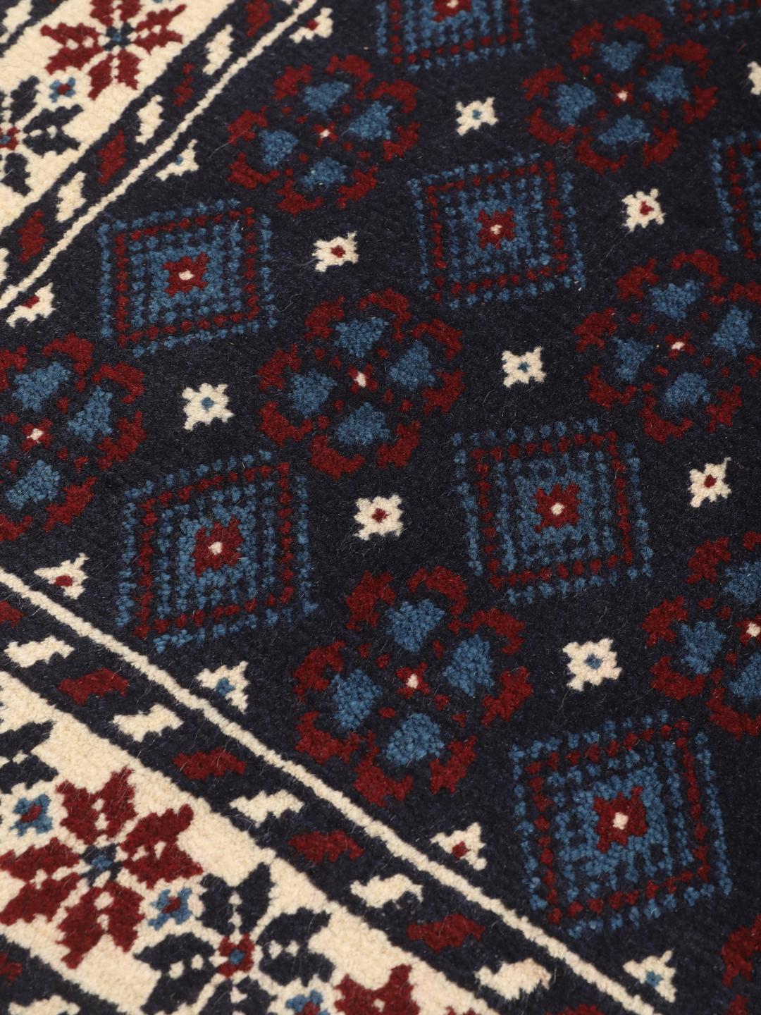 Handgeknoopt Beluch-tapijt uit het Midden-Oosten in blauwe, rode en beige tinten.