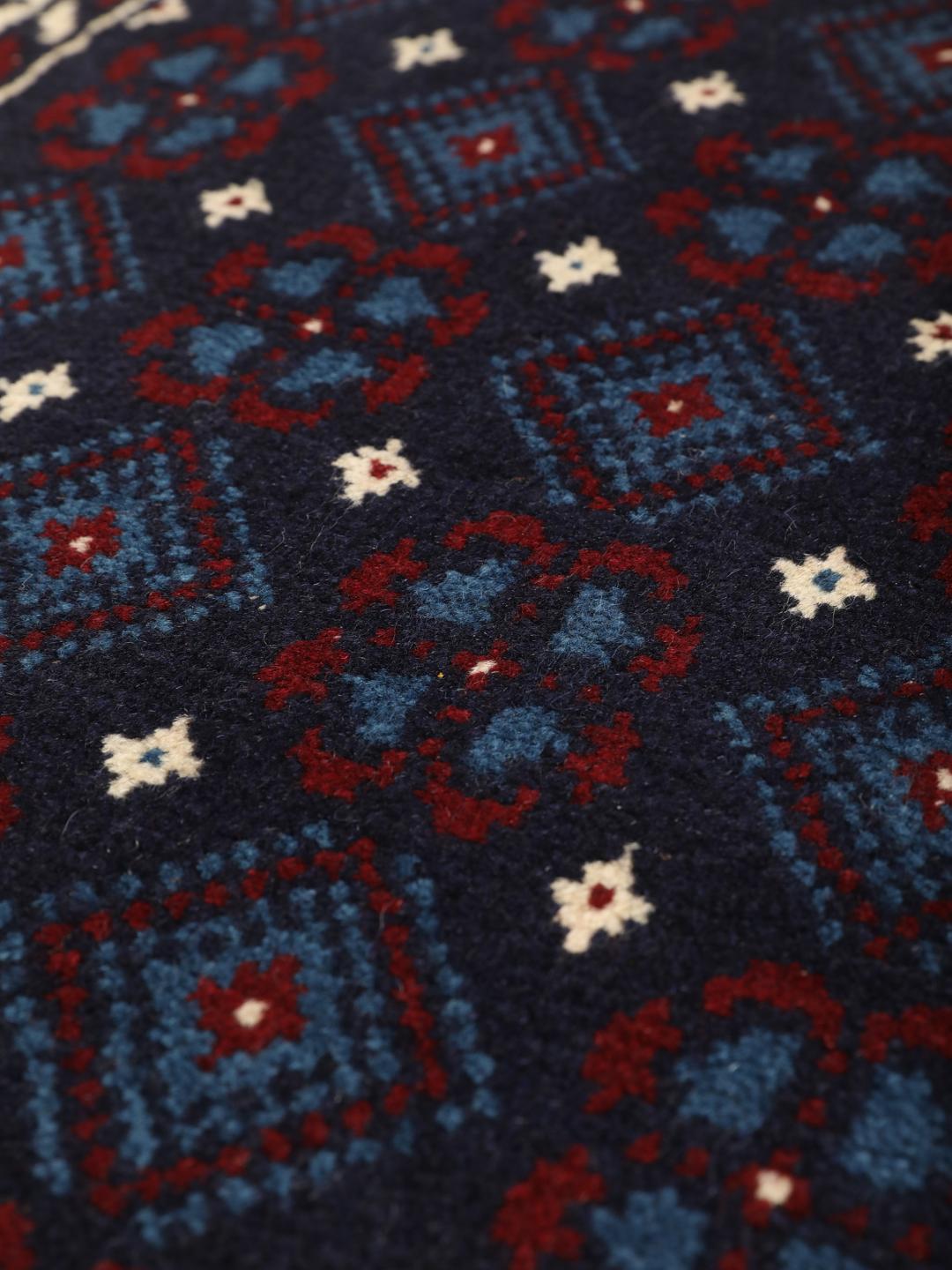 Handgeknoopt Beluch-tapijt uit het Midden-Oosten in blauwe, rode en beige tinten.