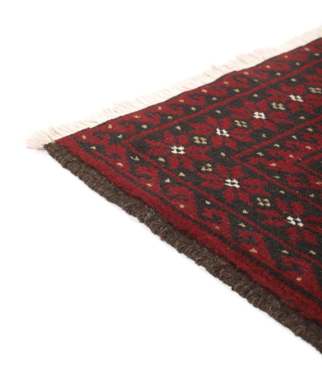 A small, one-of-a-kind Baluch rug from the Middle East with a dark-red and black geometric pattern.