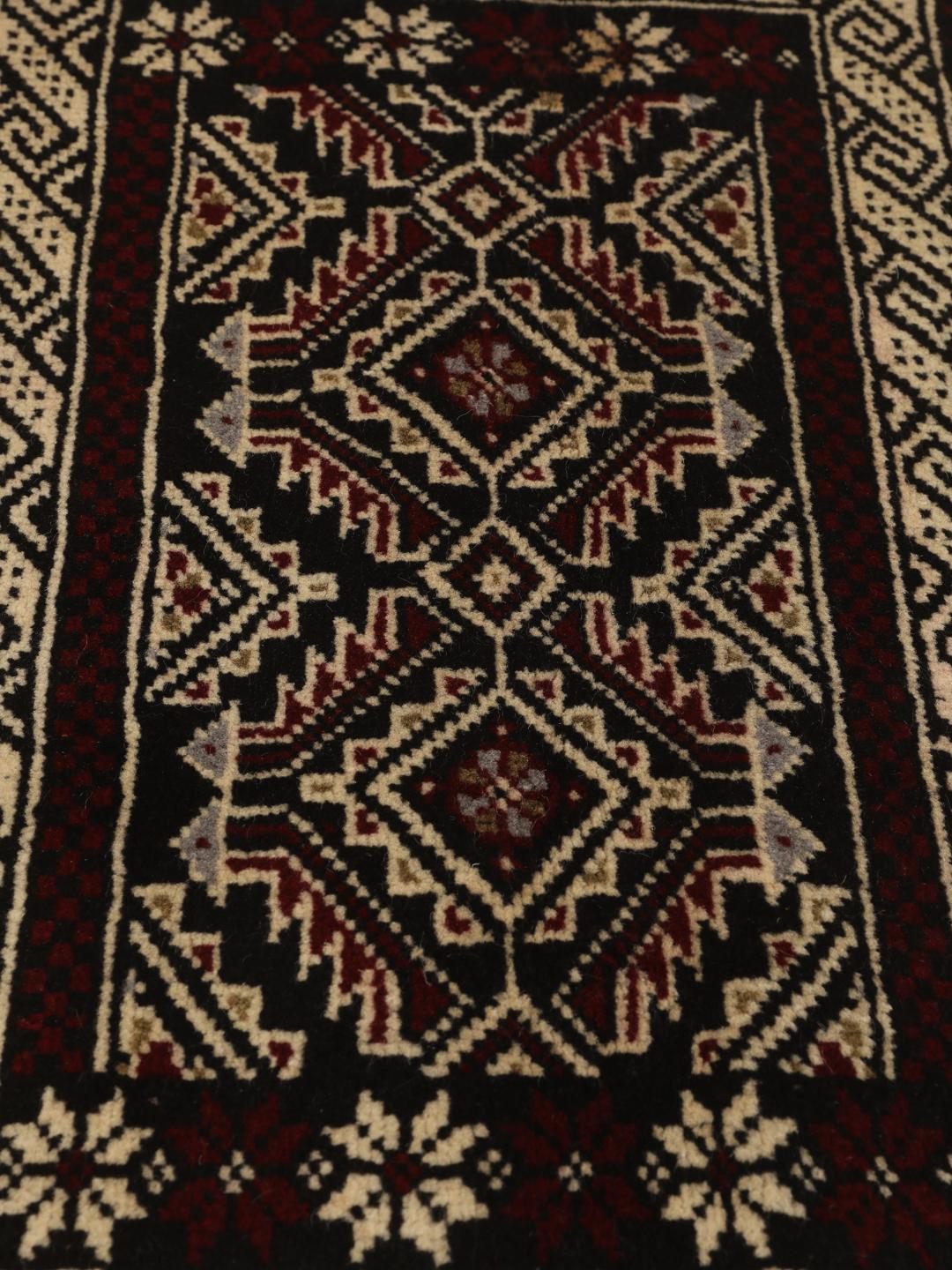Håndknyttet Beluch-tæppe med geometriske motiver i mørkerødt og sort fra Mellemøsten.