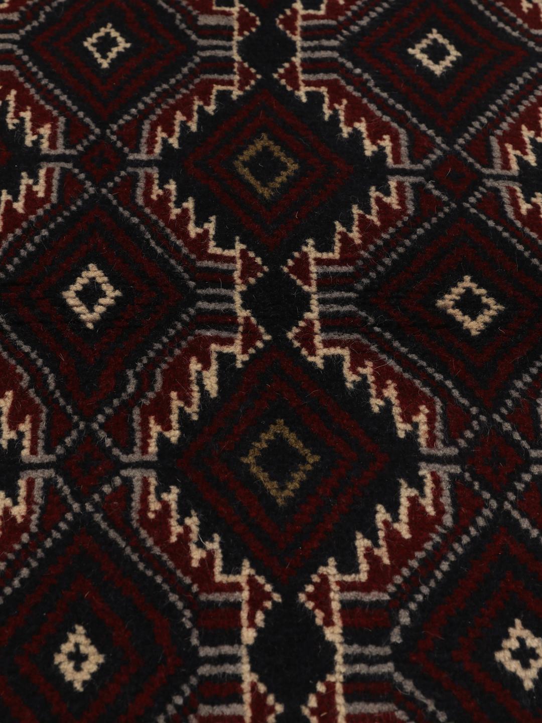 Hand-knotted Baluch rug with geometric patterns in dark red and dark blue tones