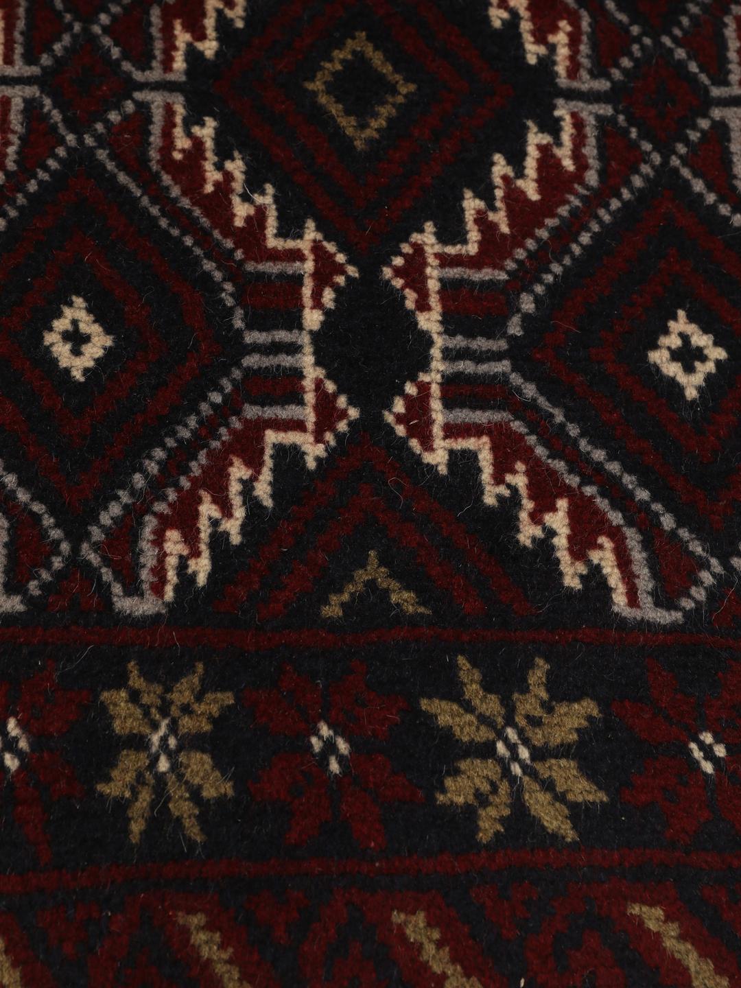 Hand-knotted Baluch rug with geometric patterns in dark red and dark blue tones