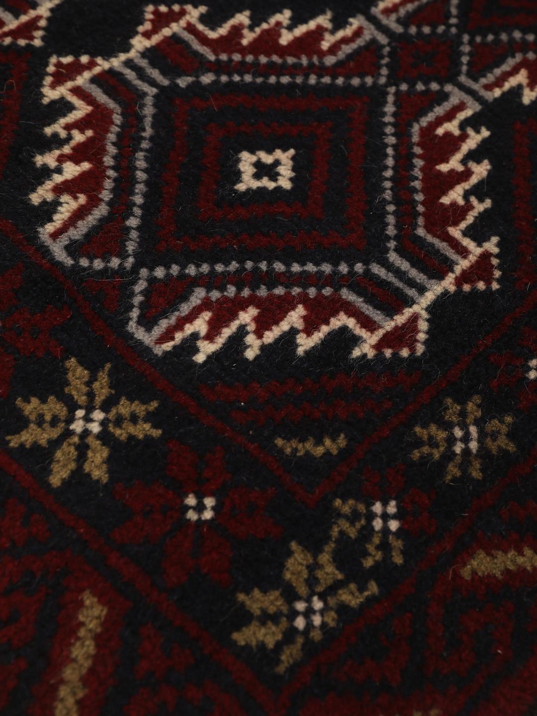 Hand-knotted Baluch rug with geometric patterns in dark red and dark blue tones