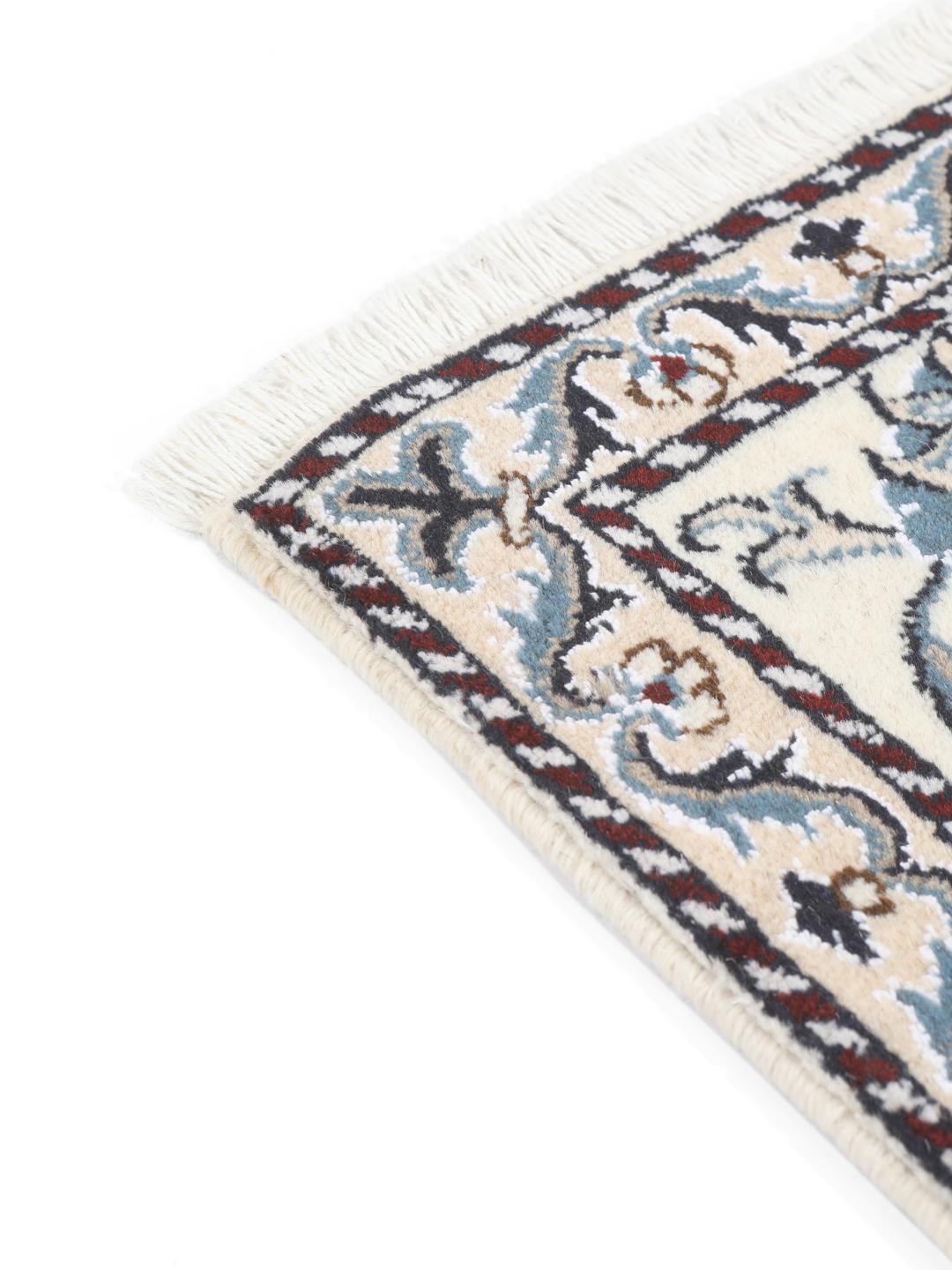 A hand-knotted floral Nain rug from the Middle East in beige and blue tones.