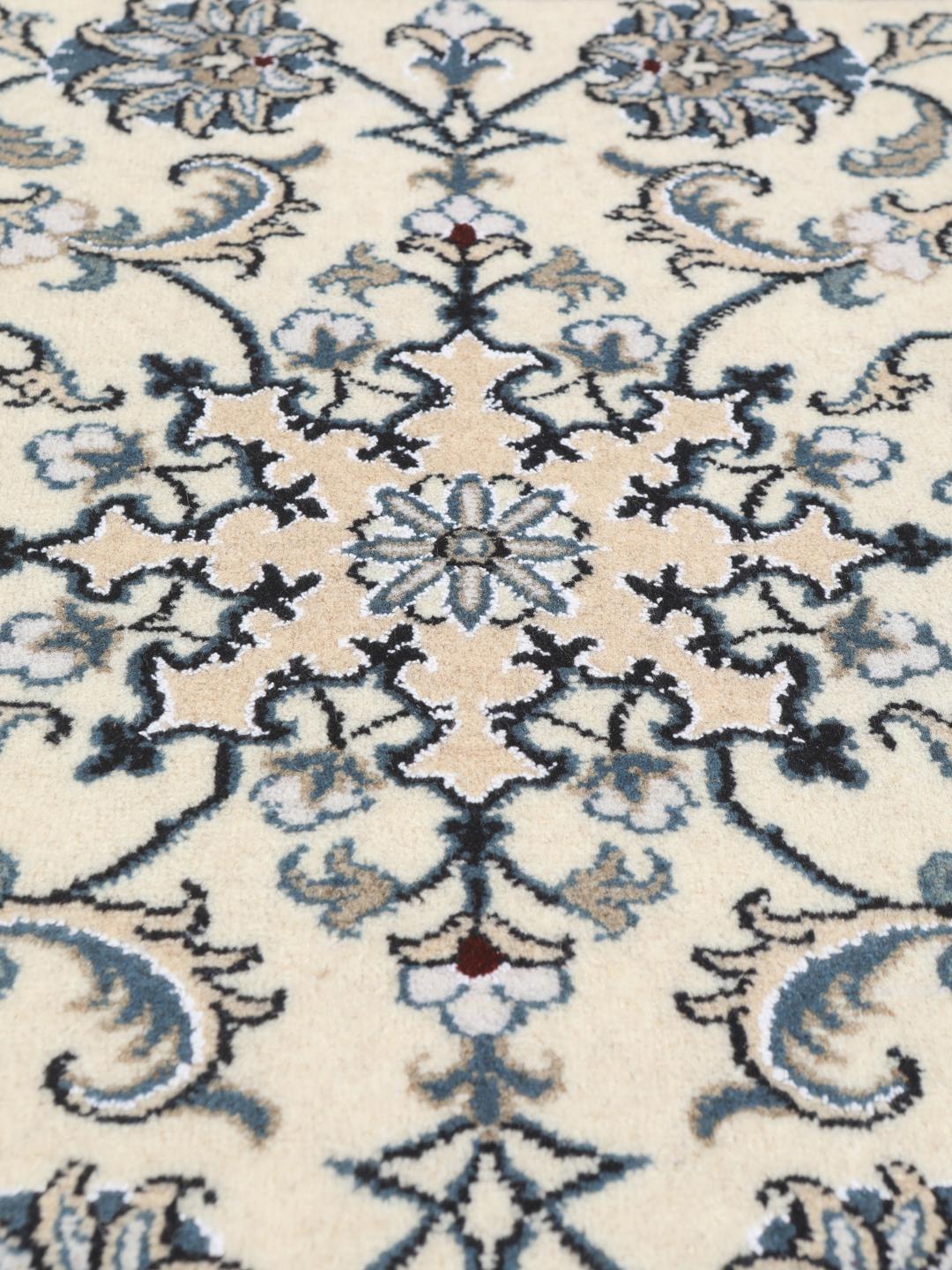 A hand-knotted floral Nain rug from the Middle East in beige and blue tones.