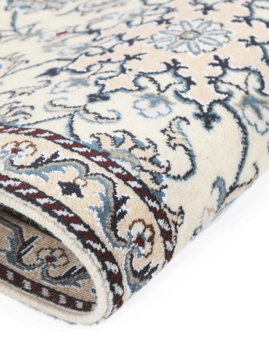 A hand-knotted floral Nain rug from the Middle East in beige and blue tones.