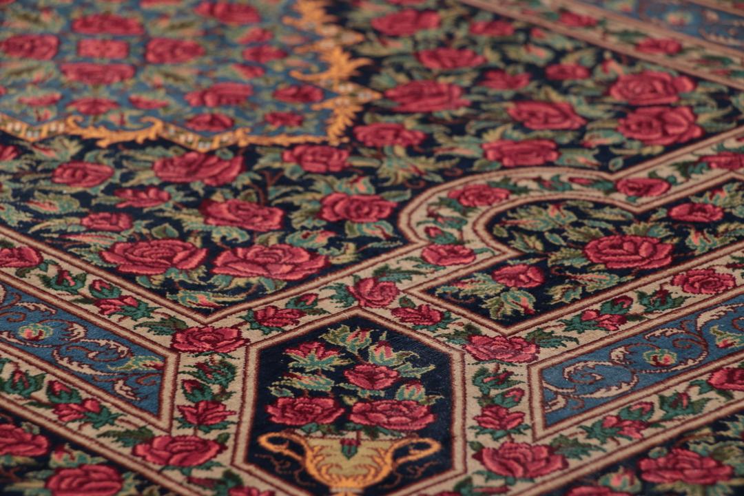 Håndknyttet mellemøstligt silketeppe i mørkeblåt og rødt med traditionelle blomstermotiver