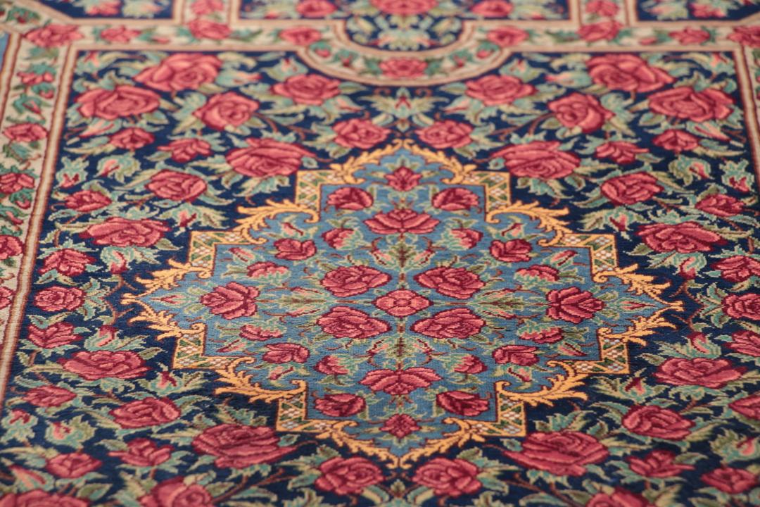 Håndknyttet mellemøstligt silketeppe i mørkeblåt og rødt med traditionelle blomstermotiver