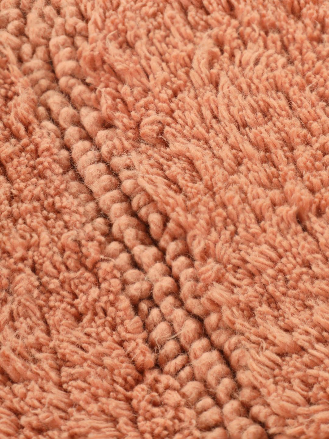 Tapis de bain rond terracotta avec un motif organique texturé