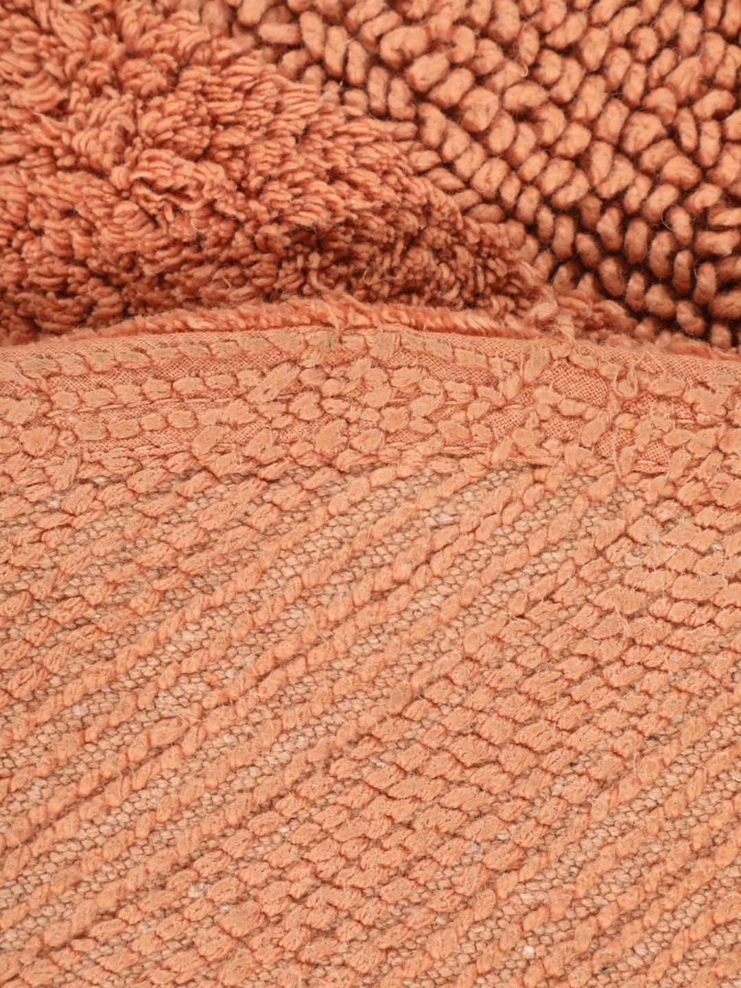Tapis de bain rond terracotta avec un motif organique texturé
