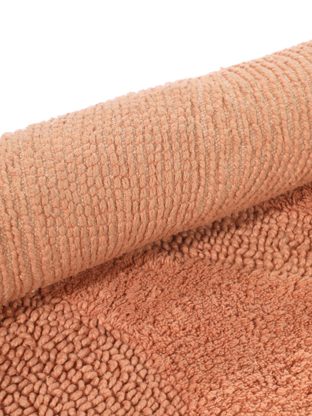 Tapis de bain rond terracotta avec un motif organique texturé
