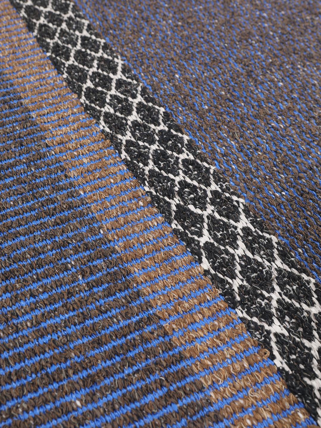 Een blauw en bruine loper met een gestreept en geometrisch patroon.