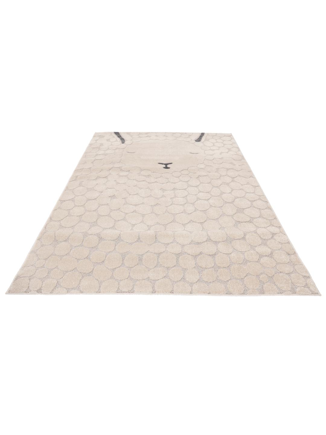 Un tapis pour enfant beige et gris présentant un motif de mouton stylisé avec une texture à poils longs et courts.