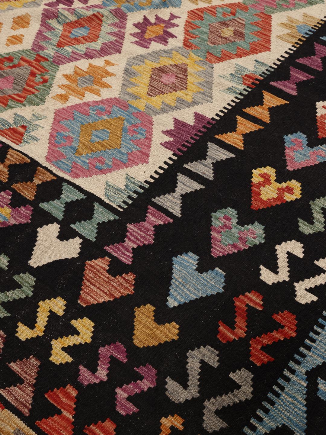 Een groot, uniek Afghan Kelim-tapijt met een levendig geometrisch ruitpatroon in een veelkleurig palet.