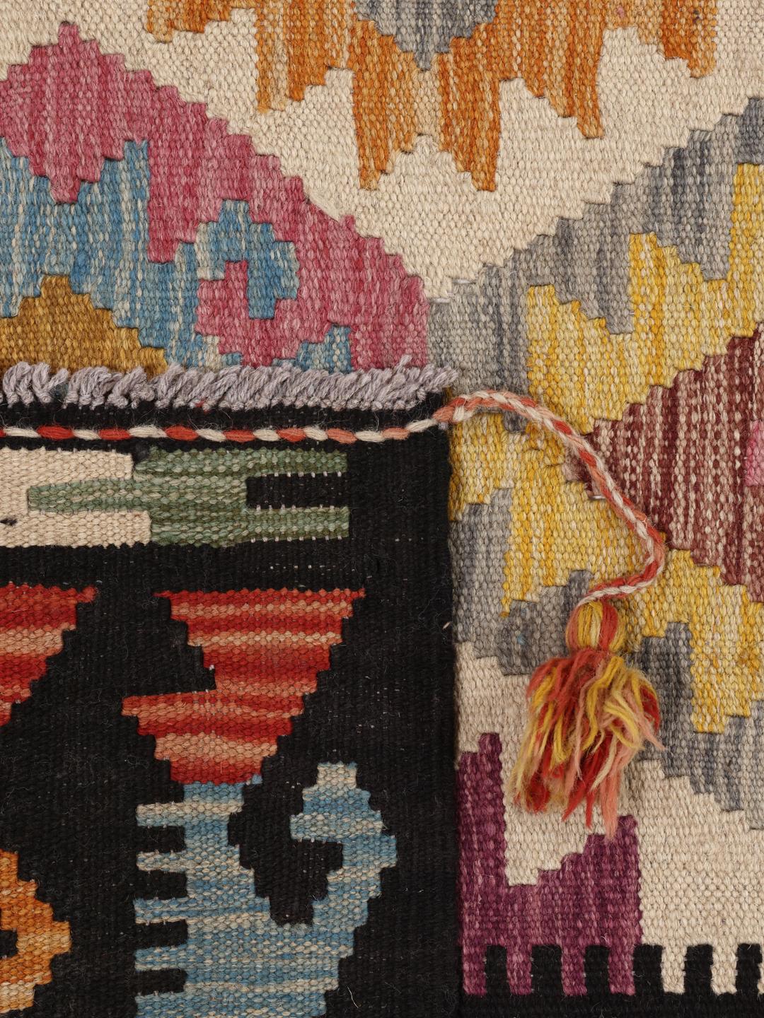 Een groot, uniek Afghan Kelim-tapijt met een levendig geometrisch ruitpatroon in een veelkleurig palet.