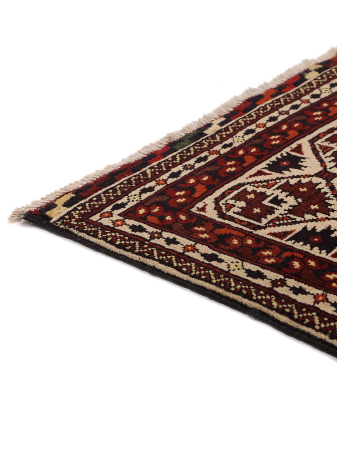 Et håndknyttet Kunduz-tæppe fra Afghanistan med geometriske motiver i rød og beige.
