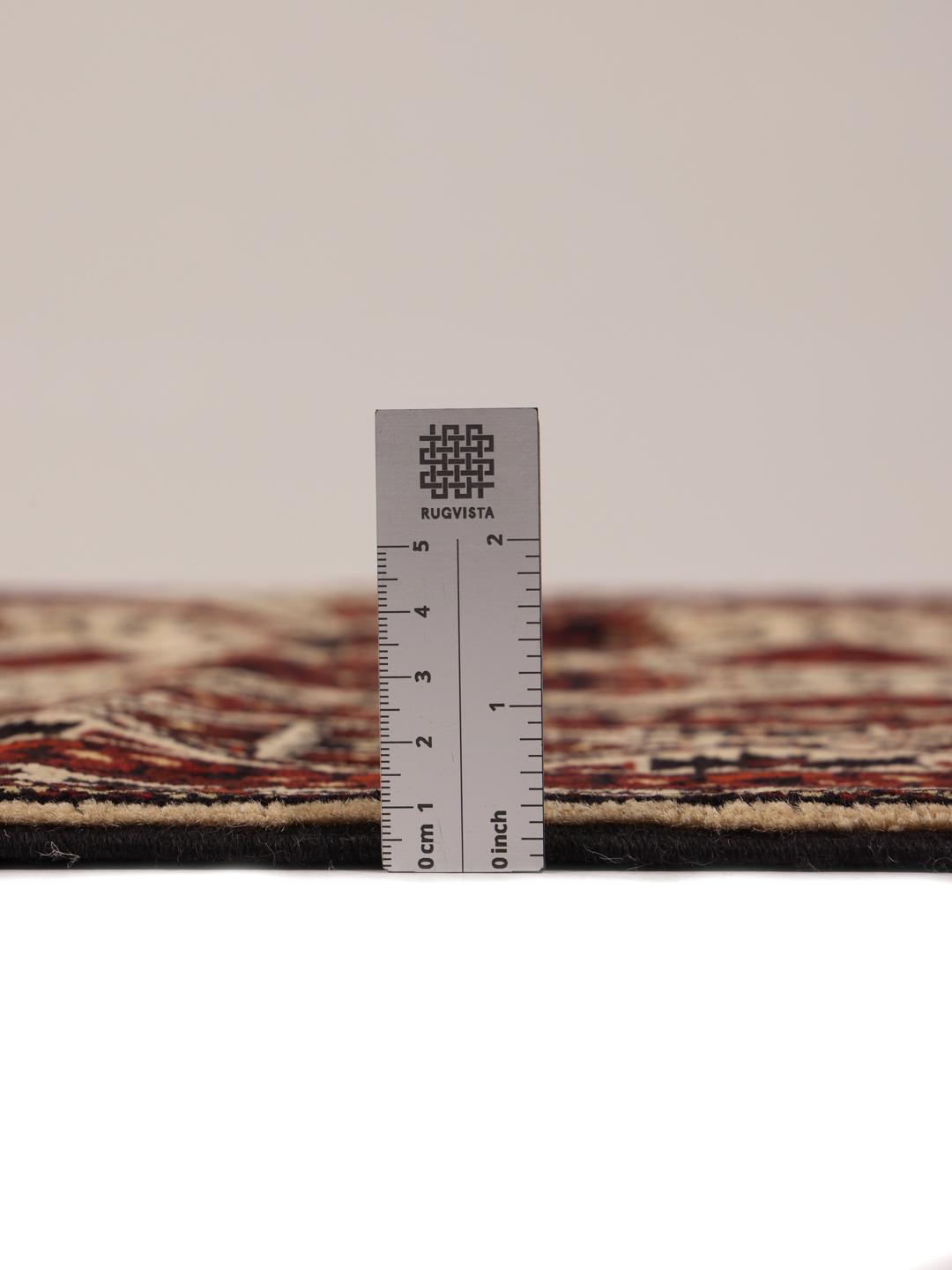 Et håndknyttet Kunduz-tæppe fra Afghanistan med geometriske motiver i rød og beige.