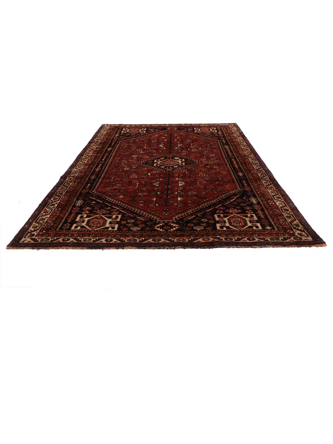 A hand-knotted Ghashghai rug from the Middle East in shades of red and black.