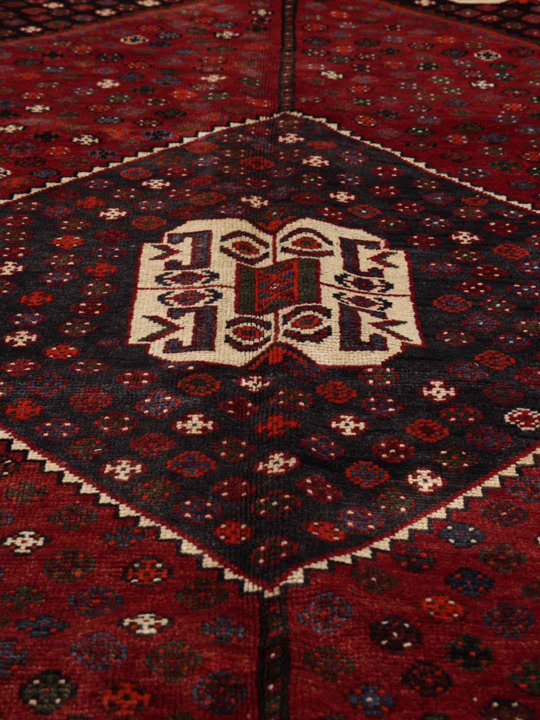 Hand-knotted Shiraz rug from the Middle East in deep red and black tones