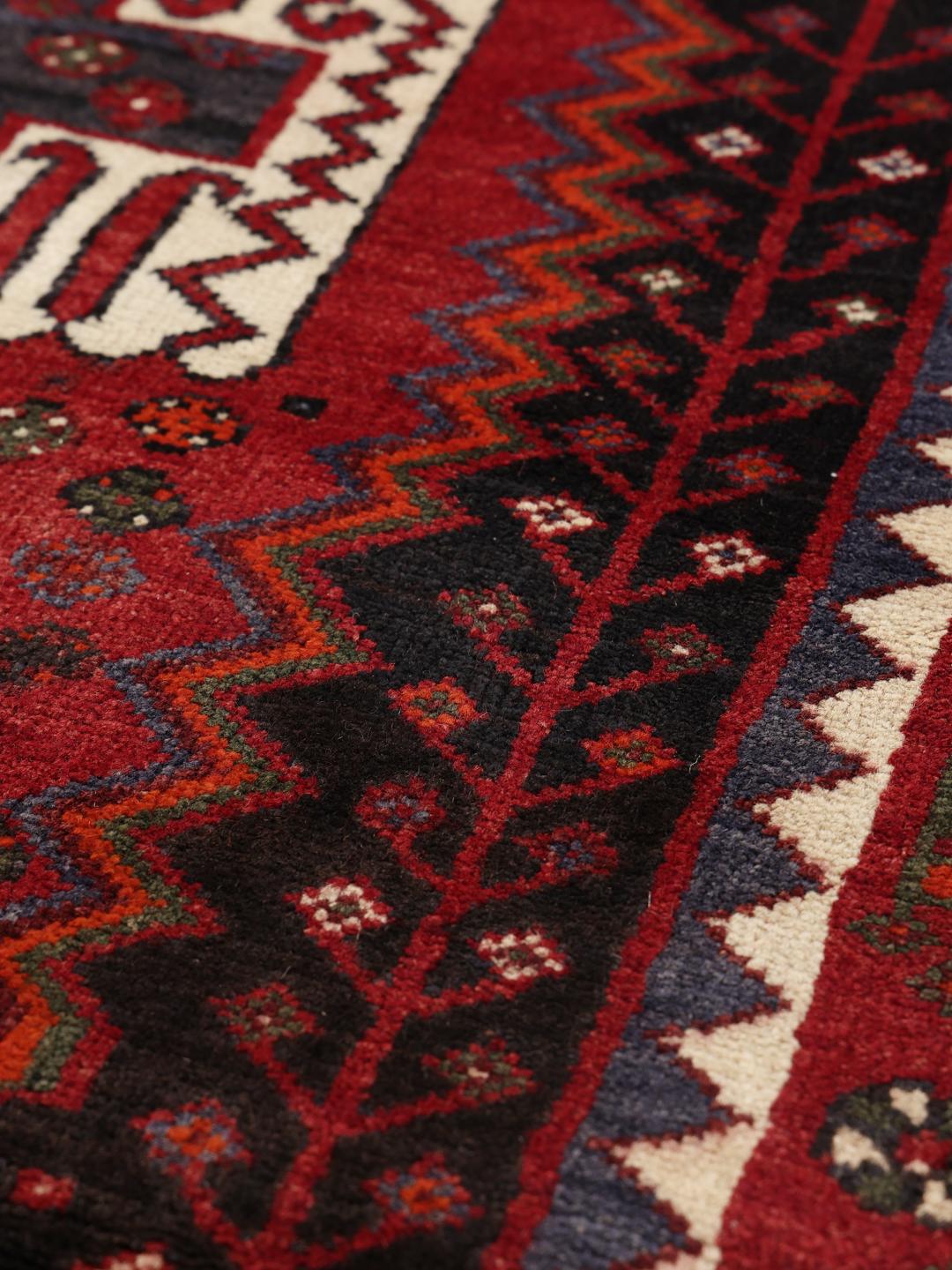 Hand-knotted Shiraz rug from the Middle East in deep red and black tones