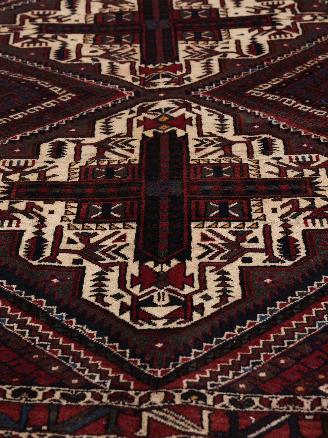 Hand-knotted Afshar Shahre Babak rug with geometric patterns in red and dark tones