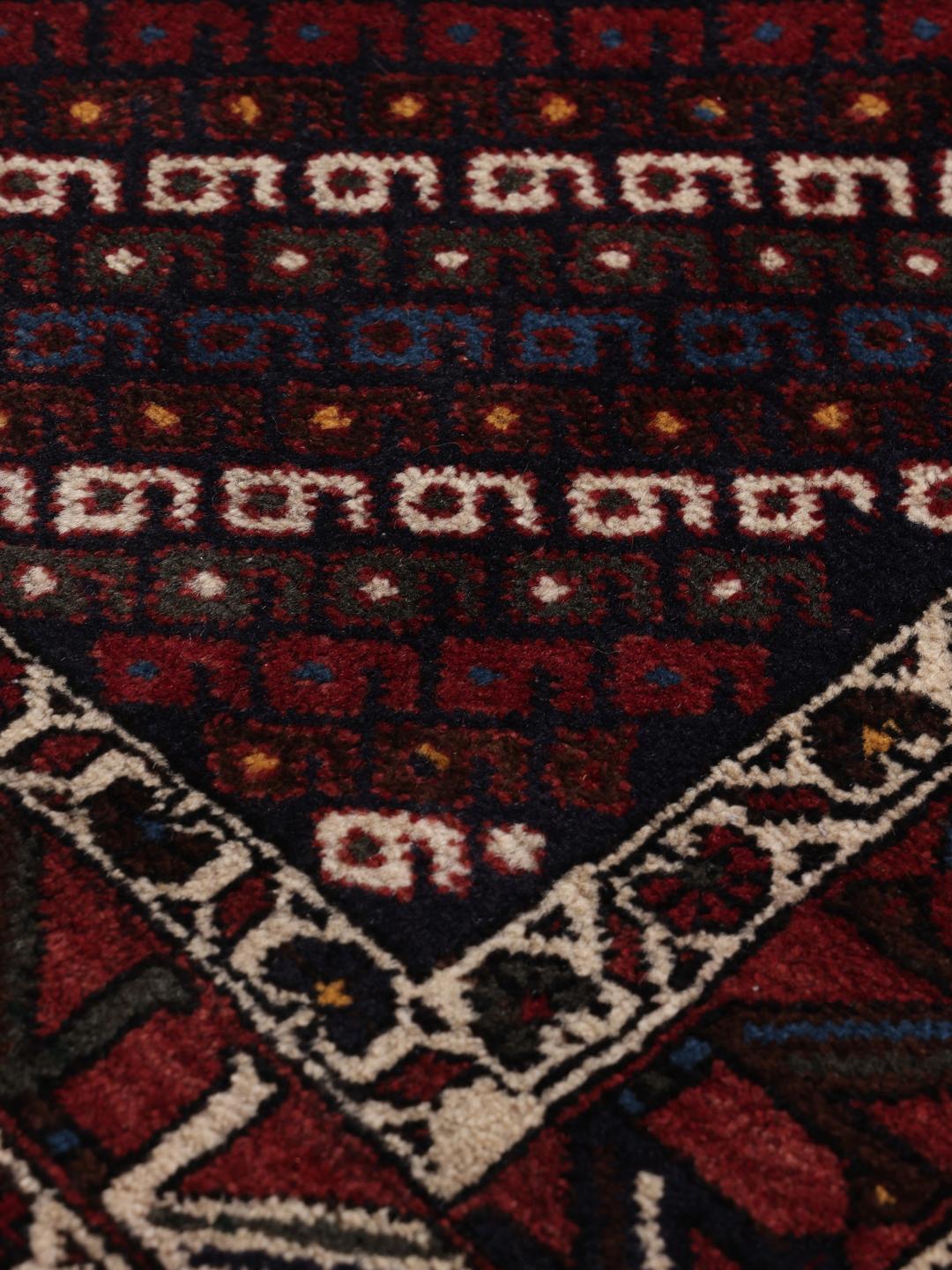 Hand-knotted Afshar Shahre Babak rug with geometric patterns in red and dark tones