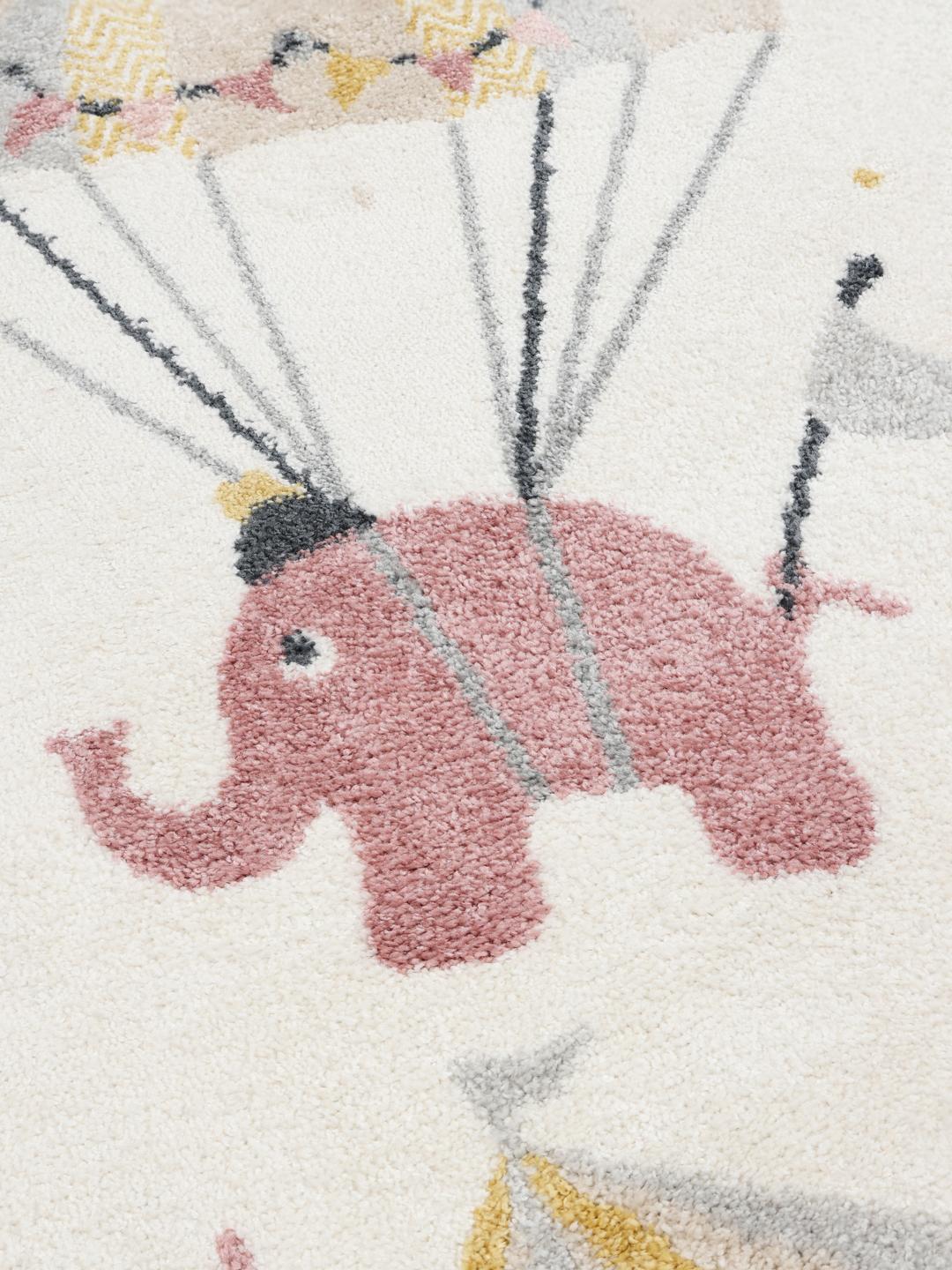 Tapis rond rose et blanc cassé avec un motif de cirque ludique