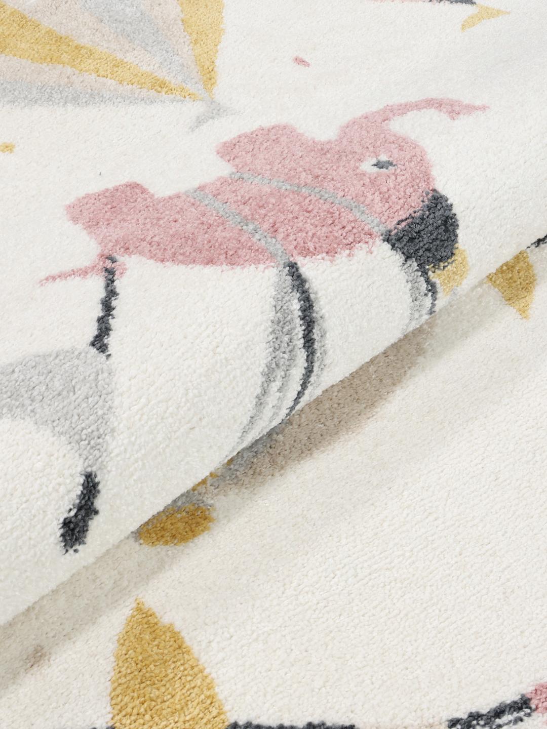 Tapis rond rose et blanc cassé avec un motif de cirque ludique