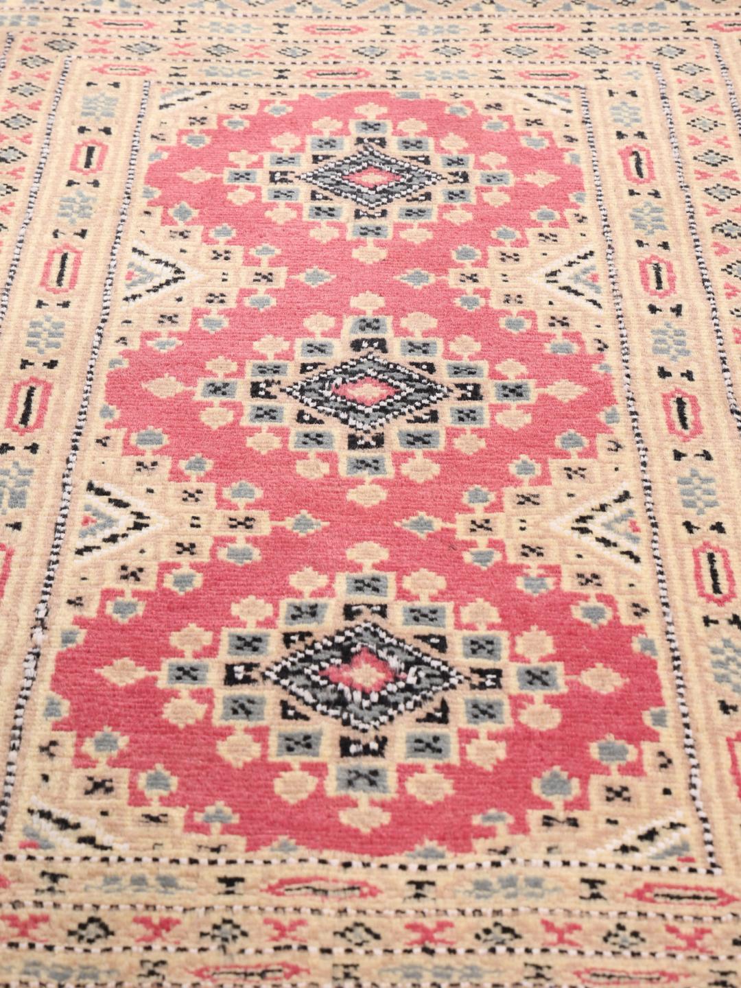 A hand-knotted red Pakistan Bokhara 2ply rug with geometric motifs