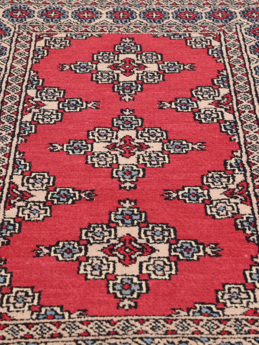 Hand-knotted Pakistan Bokhara rug in red with geometric motifs