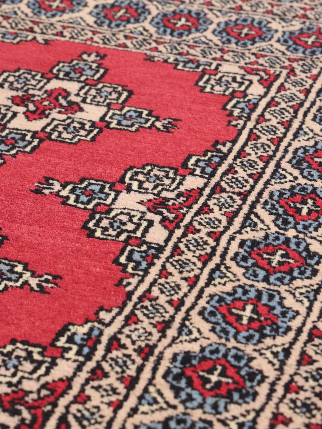 Hand-knotted Pakistan Bokhara rug in red with geometric motifs