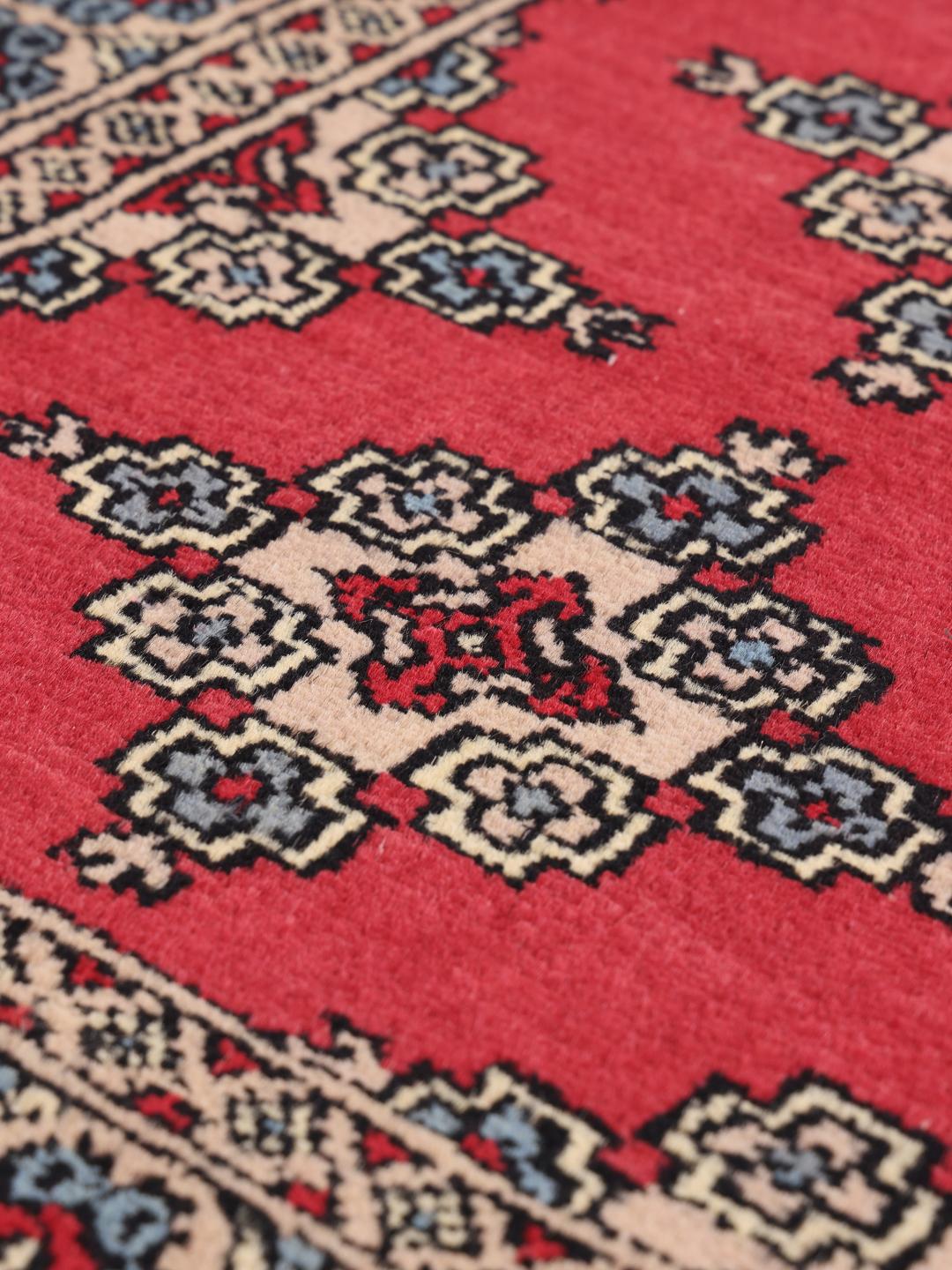 Hand-knotted Pakistan Bokhara rug in red with geometric motifs