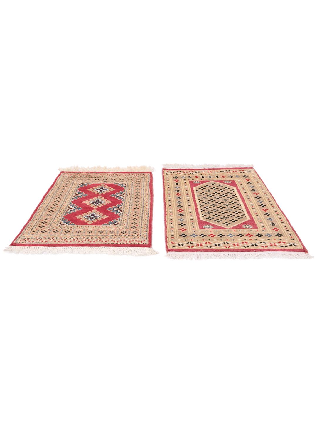 A set of two rectangular hand-knotted red Pakistan Bokhara rugs with intricate geometric patterns