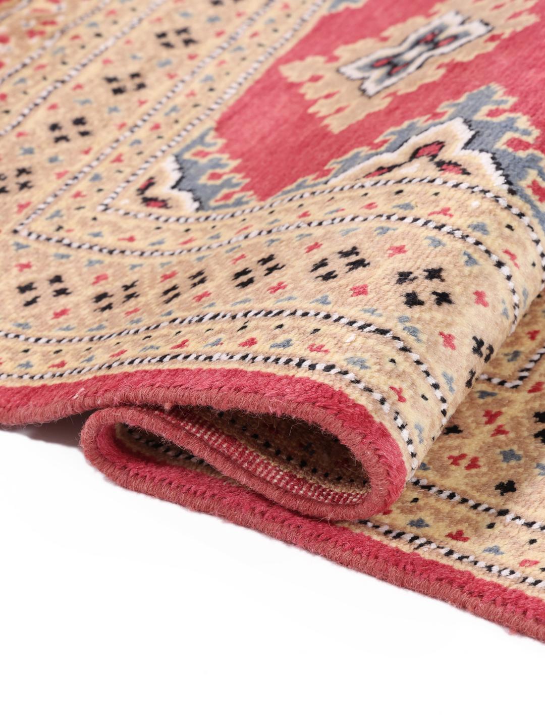 A set of two rectangular hand-knotted red Pakistan Bokhara rugs with intricate geometric patterns