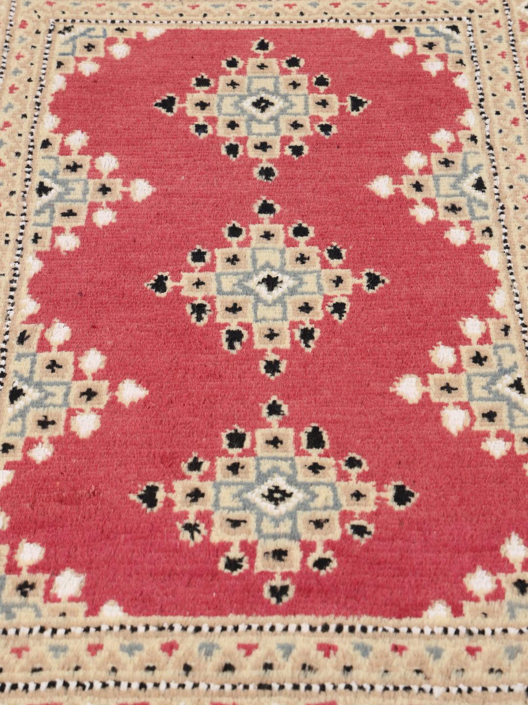 Hand-knotted wool rug from Pakistan in red and blue tones