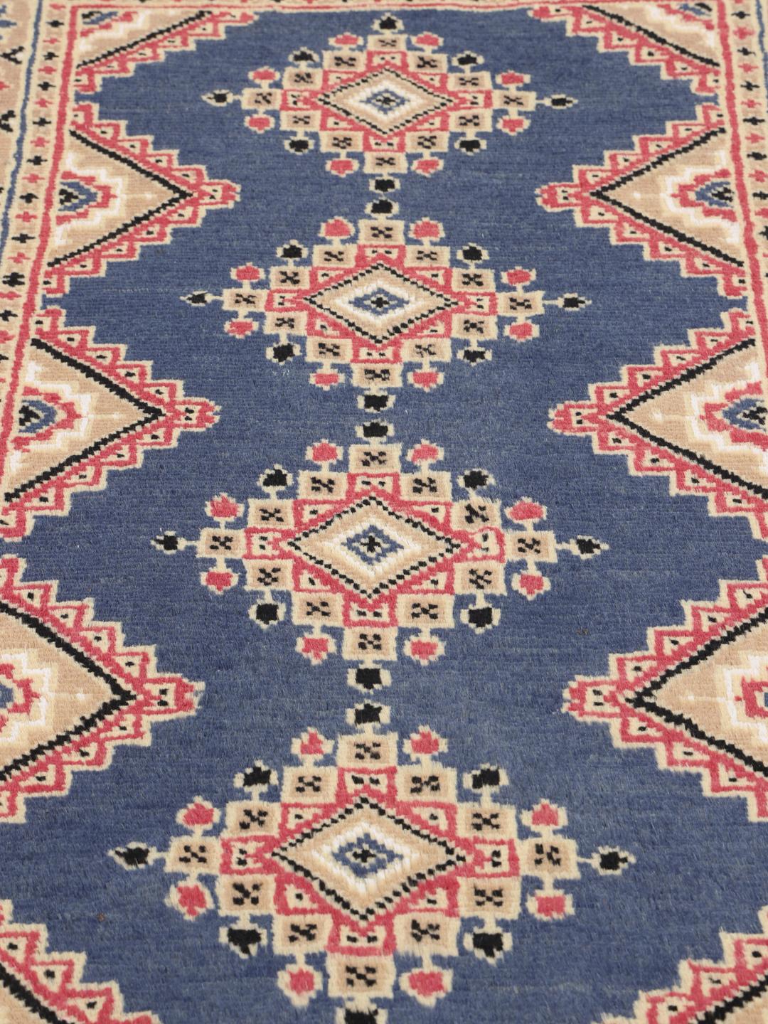 Hand-knotted wool rug from Pakistan in red and blue tones