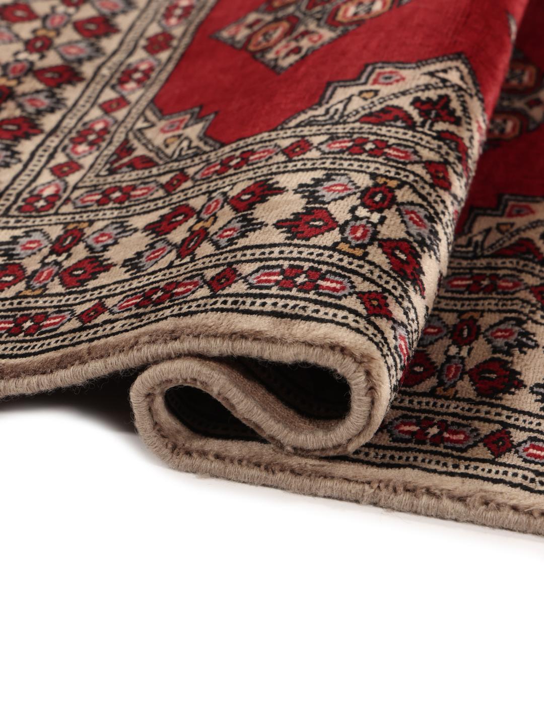 Hand-knotted Pakistan Bokhara rug with a red field and geometric motifs