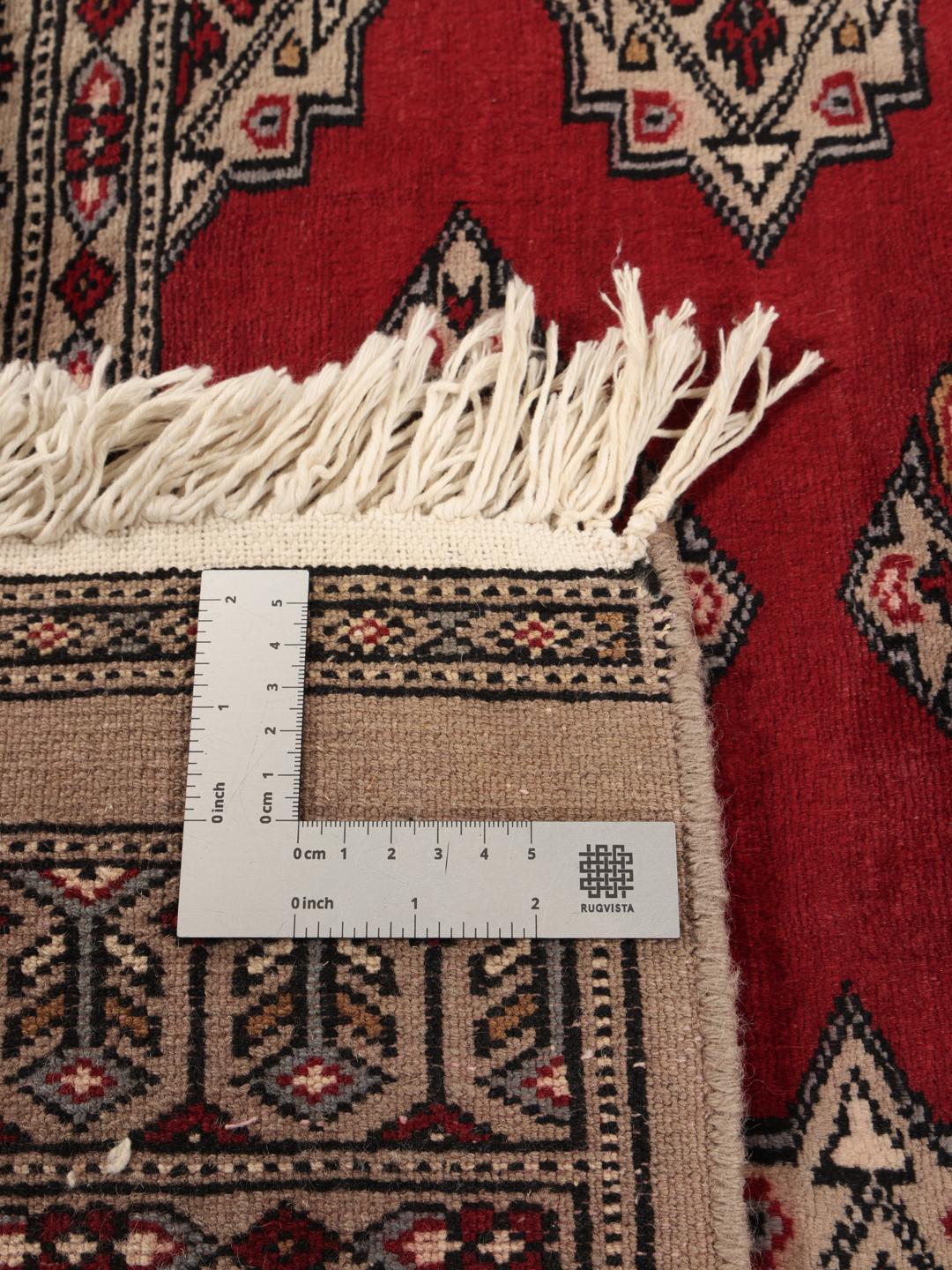 Hand-knotted Pakistan Bokhara rug with a red field and geometric motifs