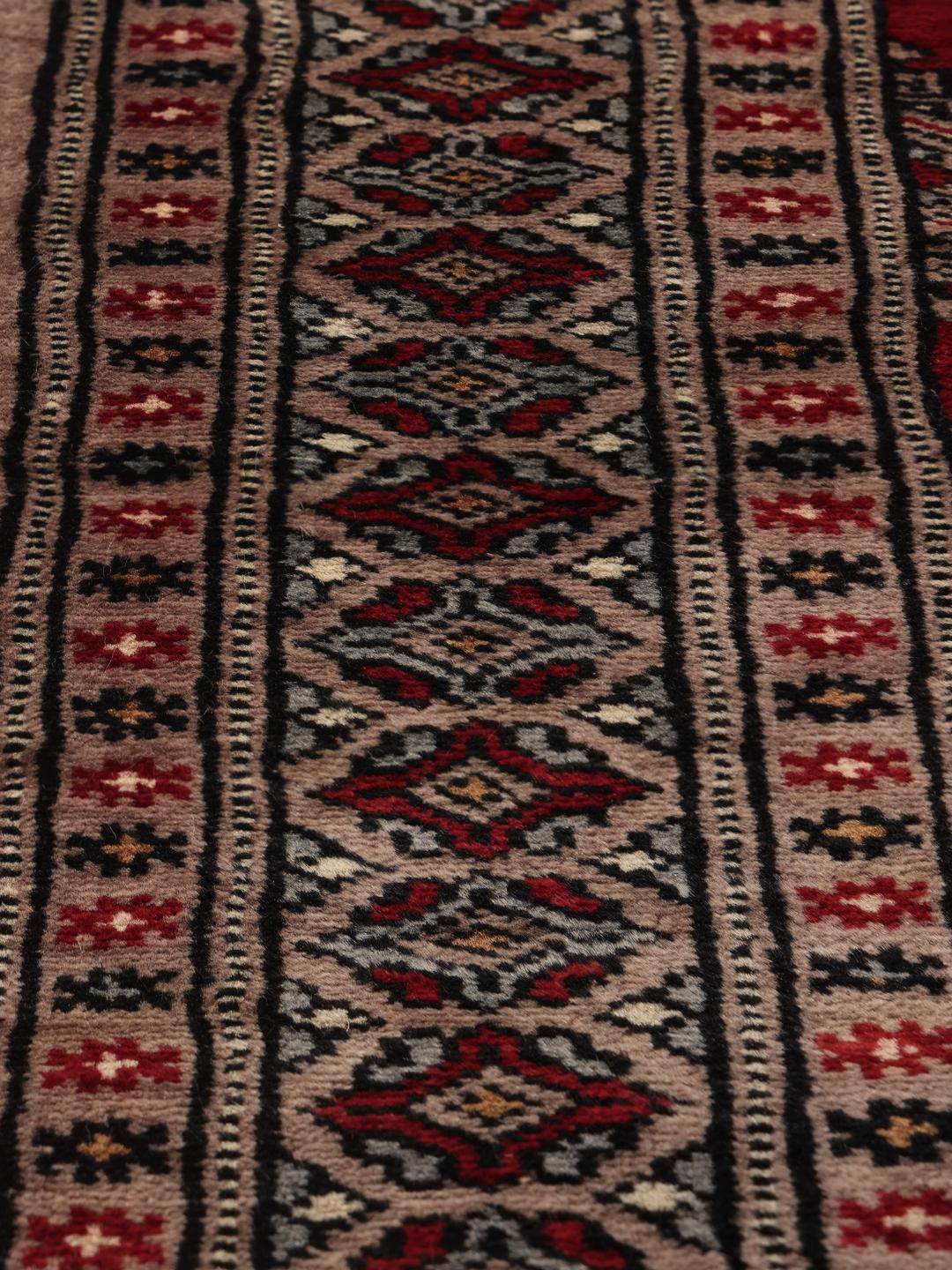 Hand-knotted Pakistan Bokhara rug with a red field and geometric motifs